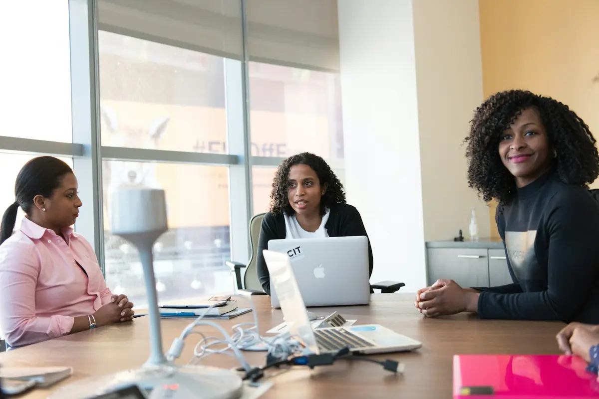 Trois femmes travaillent avec des ordinateurs portables autour d'une table